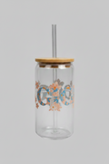 Clear glass jar with a wooden lid held by a hand, with a blurred background.
